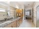 Primary bathroom featuring double sinks, granite counters, and a glass-enclosed shower at 2772 Southland St, St Cloud, FL 34772