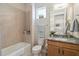 Well-lit bathroom features a granite countertop vanity, tiled shower, and decorative accents at 2772 Southland St, St Cloud, FL 34772