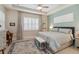 Cozy bedroom featuring a tray ceiling, plantation shutters, and a sitting area with a desk at 2772 Southland St, St Cloud, FL 34772