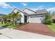 Inviting single-story home featuring a well-maintained lawn, brick driveway, and two-car garage at 2772 Southland St, St Cloud, FL 34772