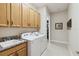 Spacious laundry room featuring wooden cabinets, granite countertops, and a modern washer and dryer at 2772 Southland St, St Cloud, FL 34772