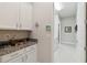 Well-organized laundry room featuring granite countertops, ample cabinet space, and an adjacent hallway at 2772 Southland St, St Cloud, FL 34772