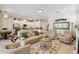 Open living room with sofas, fireplace, and a view of the kitchen with stainless steel appliances at 2772 Southland St, St Cloud, FL 34772