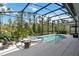Screened pool and spa are surrounded by lush landscaping and tile patio at 2772 Southland St, St Cloud, FL 34772
