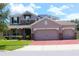 Charming two-story home with a three car garage, stone accents, and a well-manicured lawn at 2805 Carter Grove Ln, Kissimmee, FL 34741