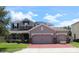 Charming two-story home with a brick driveway and stone accents, plus a three-car garage for ample parking at 2805 Carter Grove Ln, Kissimmee, FL 34741