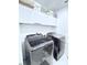 Modern laundry room with front loading washer and dryer and overhead cabinets for storage at 2805 Carter Grove Ln, Kissimmee, FL 34741