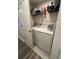Convenient laundry room with modern washer and dryer, plus storage shelves at 293 Fiddlewood Ct, Davenport, FL 33837