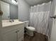 Bathroom with a single sink vanity, toilet, and shower behind a patterned curtain at 3050 Old Soldier Rd, Lakeland, FL 33810