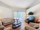 Bright living room with wood floors and sliding glass doors that offer a view of the pool area at 3158 Forest Breeze Way, St Cloud, FL 34771