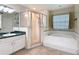 Bathroom featuring a glass enclosed shower, bathtub, and vanity with ample counter space at 3158 Forest Breeze Way, St Cloud, FL 34771