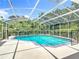 Refreshing screened-in backyard pool surrounded by lush landscaping and bright sky at 3158 Forest Breeze Way, St Cloud, FL 34771