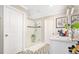 Bright bathroom featuring glass shower, white cabinets and vanity area with geometric patterned tile floors at 31792 Broadwater Ave, Leesburg, FL 34748