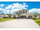 Two-story home showing a three-car garage, large driveway and beautiful lawn at 31792 Broadwater Ave, Leesburg, FL 34748