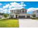 Charming two-story home featuring a three car garage, manicured lawn, and impeccable landscaping at 31792 Broadwater Ave, Leesburg, FL 34748