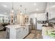 Bright kitchen features stainless steel appliances, white cabinets, large island and modern pendant lighting at 31792 Broadwater Ave, Leesburg, FL 34748