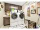 Neat laundry room featuring a washer, dryer, storage and decorative signs at 31792 Broadwater Ave, Leesburg, FL 34748