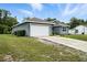 A cozy single-story home with a two-car garage and a well-kept lawn under a sunny sky at 3390 George Sauls St, Deltona, FL 32738