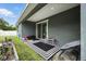 Cozy covered patio with sliding glass doors, black & white rug, seating, and grill at 3390 George Sauls St, Deltona, FL 32738