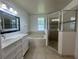 Bathroom featuring a soaking tub, walk-in shower and double sink vanity at 343 Marquee Dr, Kissimmee, FL 34758