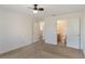 Bedroom has neutral carpet and ceiling fan with open doorway to bathroom at 364 Fish Hawk Dr, Winter Haven, FL 33884