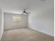 Bright bedroom features neutral carpet, one window, and ceiling fan at 364 Fish Hawk Dr, Winter Haven, FL 33884