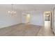 Open living room with neutral carpet, tiled section, and elegant chandeliers creating a welcoming ambiance at 364 Fish Hawk Dr, Winter Haven, FL 33884