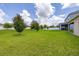 Large backyard with lush lawn, mature trees, and white fence, offering privacy at 371 Pinecrest Loop, Davenport, FL 33837