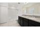 Bathroom featuring dual sinks, granite counters, and a white shower at 371 Pinecrest Loop, Davenport, FL 33837