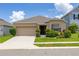 Charming single-story home with a well-manicured lawn and a two-car garage at 371 Pinecrest Loop, Davenport, FL 33837