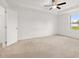 Large primary bedroom featuring a tray ceiling and a window overlooking the yard at 371 Pinecrest Loop, Davenport, FL 33837