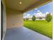 Covered patio area overlooks the expansive backyard with lush green grass and mature trees at 371 Pinecrest Loop, Davenport, FL 33837