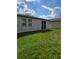 A serene backyard with lush green grass, bright sky, and a glimpse of neighboring homes at 3839 Marbella Way, Davenport, FL 33897