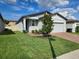 Well-maintained home with a neatly manicured lawn and a tree in the front yard at 3839 Marbella Way, Davenport, FL 33897