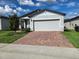 Charming single-story home with a brick driveway and attached two-car garage at 3839 Marbella Way, Davenport, FL 33897