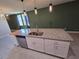 Granite kitchen island with sink and cabinets in a modern, open-concept kitchen at 3839 Marbella Way, Davenport, FL 33897