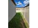 Side yard featuring healthy green grass between house and privacy fence under sunny skies at 3839 Marbella Way, Davenport, FL 33897