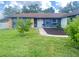 Charming blue home with stone accents, lush lawn, and walkway to the front door at 421 Bridle Path, Casselberry, FL 32707