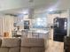 Open kitchen featuring white cabinets, granite countertops, stainless steel appliances, and a breakfast bar at 421 Bridle Path, Casselberry, FL 32707