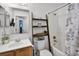 Bathroom with a sink, toilet, and a shower/tub combo with decorative wooden ladder for storage at 447 Hammerstone Ave, Haines City, FL 33844