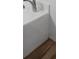 Bright, modern bathroom features white countertops and wood-look floors, combining style and functionality seamlessly at 447 Hammerstone Ave, Haines City, FL 33844