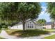 Landscaped yard of this home with mature trees and a neatly maintained lawn on a sunny day at 447 Hammerstone Ave, Haines City, FL 33844