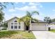 Charming single-story home with a well-manicured lawn and a beautiful palm tree in the front yard at 447 Hammerstone Ave, Haines City, FL 33844