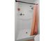 Clean shower with white tiled walls, a dual shower head, and a peach-colored curtain, creating a fresh and functional space at 447 Hammerstone Ave, Haines City, FL 33844