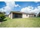 Large backyard with a screened lanai, green grass, and partial fencing offering privacy at 4928 Cortland Dr, Davenport, FL 33837