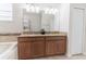 Bathroom with a double vanity, granite counters, soaking tub and glass enclosed shower at 4928 Cortland Dr, Davenport, FL 33837