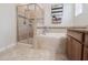 Elegant bathroom featuring a glass enclosed shower and a soaking tub with decorative tile at 4928 Cortland Dr, Davenport, FL 33837