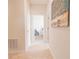 Hallway with tile floors leading to a bedroom with a chair, wall art adding character at 4928 Cortland Dr, Davenport, FL 33837