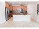 Modern kitchen with stainless steel appliances, kitchen island, tiled backsplash, and wooden cabinetry at 4928 Cortland Dr, Davenport, FL 33837