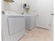 Functional laundry room with white appliances and tile flooring at 4928 Cortland Dr, Davenport, FL 33837
